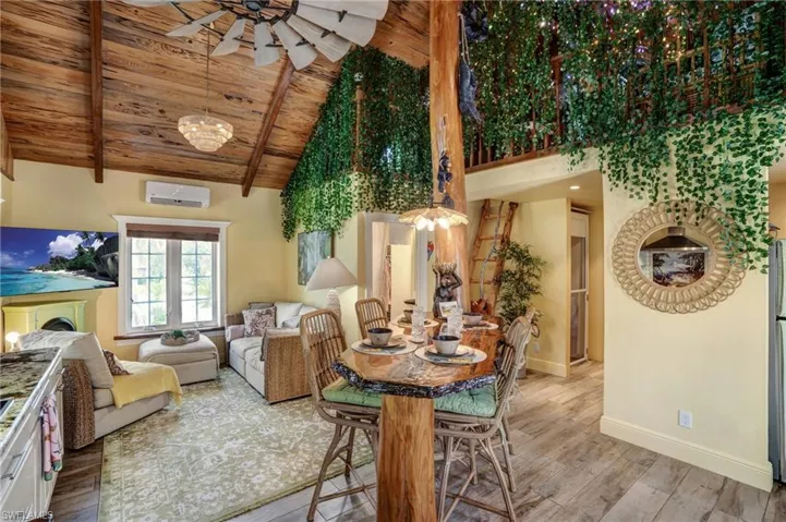 Dining area featuring light wood-style flooring, plenty of natural light, wooden ceiling, ceiling fan, and high vaulted ceiling - Virtually Edited Image