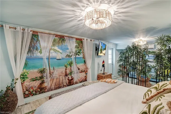 Bedroom featuring a chandelier, wood finished floors, and a wall mounted AC- Virtually Edited Image