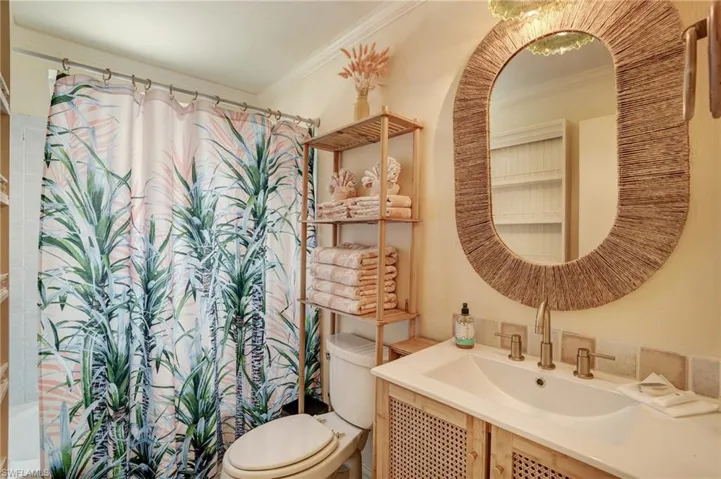 Full bath featuring toilet, vanity, and crown molding- Virtually Edited Image