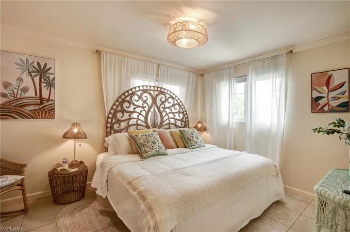 Tiled bedroom with baseboards and ornamental molding- Virtually Edited Image