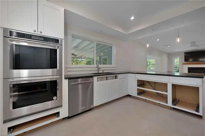 Kitchen feature stainless appliances and white shaker cabinets.