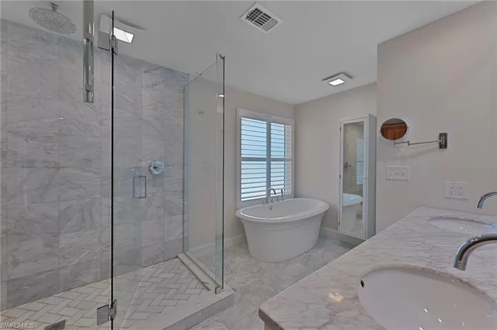 Primary ensuite bathroom features gorgeous walk-in shower, dual vanities, and a soaking tub.