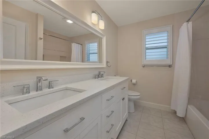 Third bathroom features quartz and dual vanities.