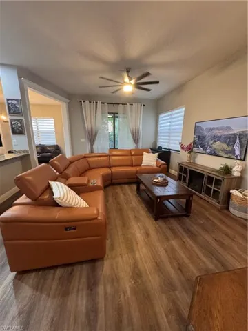 Expansive living area featuring wood-finish flooring and a ceiling fan