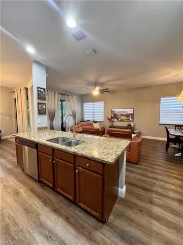 Central kitchen island featuring a double-basin sink and stainless-steel dishwasher
