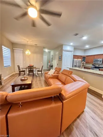Open-concept living area featuring wood-finish flooring, recessed lighting, and a ceiling fan