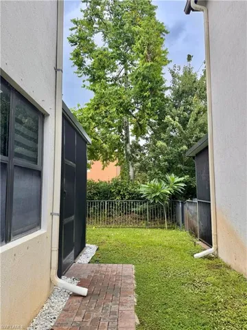 Private outdoor space featuring mature trees and a brick paver pathway