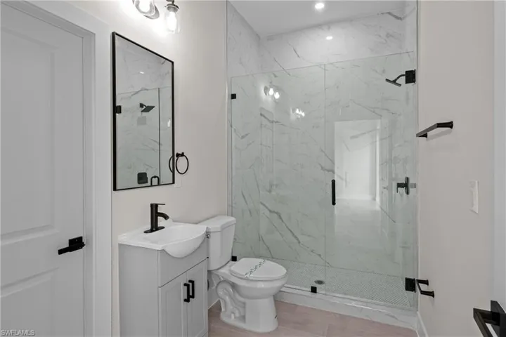 Full bathroom with vanity and a marble finish shower