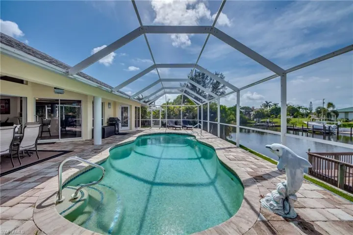 Outdoor pool with a patio area, a sunroom, a lanai, and a water view