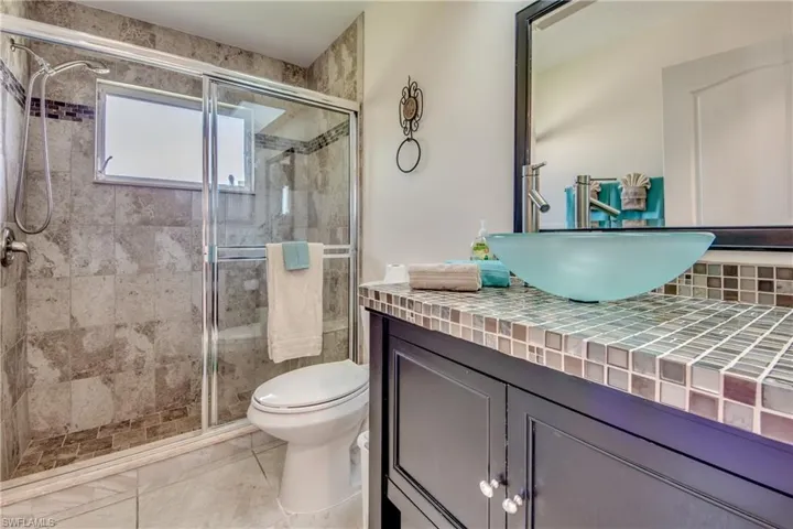 Bathroom with vanity, a shower stall, and light tile patterned floors