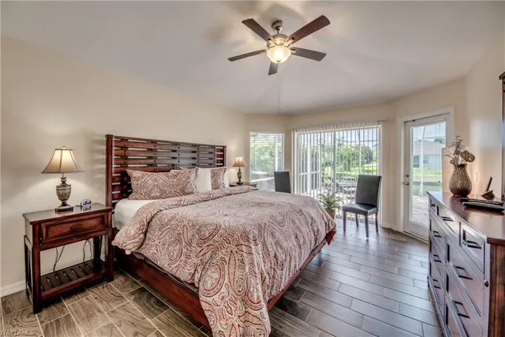 Bedroom featuring access to exterior, wood finish floors, and ceiling fan