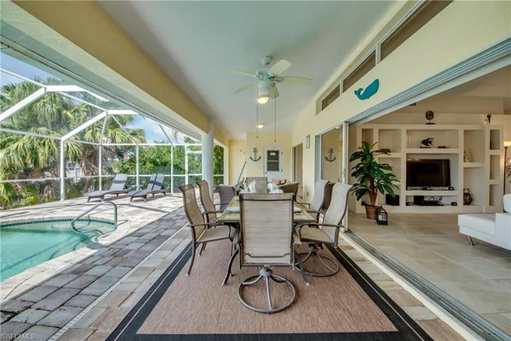 View of patio / terrace with ceiling fan, a lanai, an outdoor pool, a sunroom, and outdoor dining space