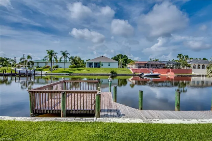 Dock with a water view, a lawn, and a residential view
