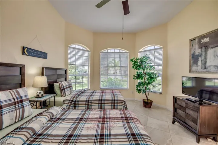 Bedroom with a ceiling fan and light tile patterned floors