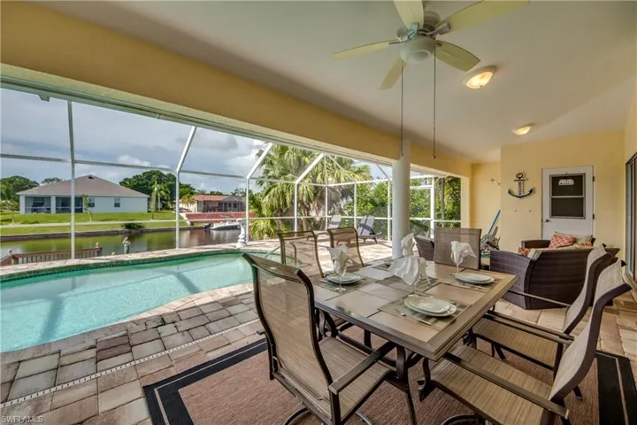 Swimming pool, a sunroom, a ceiling fan, and a patio
