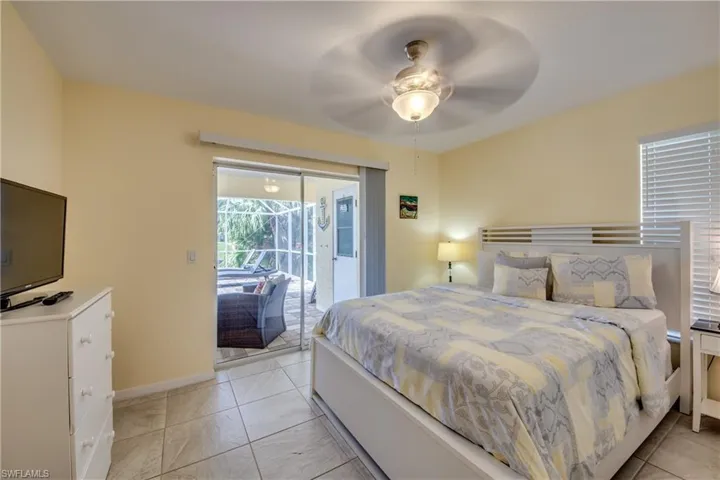 Bedroom featuring access to outside, ceiling fan, and light tile patterned floors