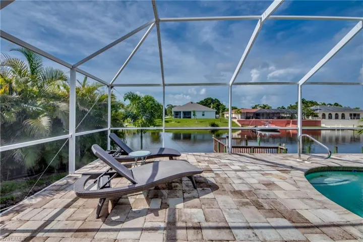 View of patio featuring a sunroom, a water view, an outdoor pool, and a dock