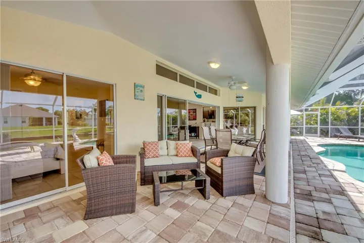 View of patio / terrace featuring a lanai, ceiling fan, outdoor lounge area, an outdoor pool, and a sunroom