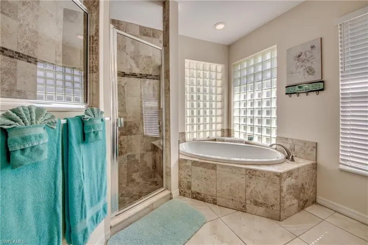 Bathroom with a garden tub, a stall shower, and tile patterned flooring