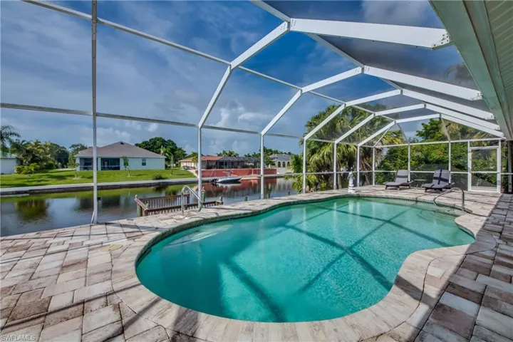 Outdoor pool with a water view, a lanai, a patio, and a sunroom