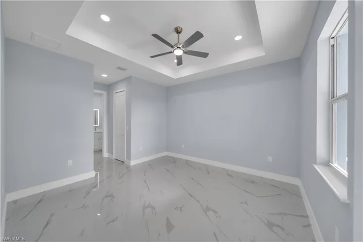 Unfurnished room featuring baseboards, recessed lighting, a raised ceiling, visible vents, and ceiling fan