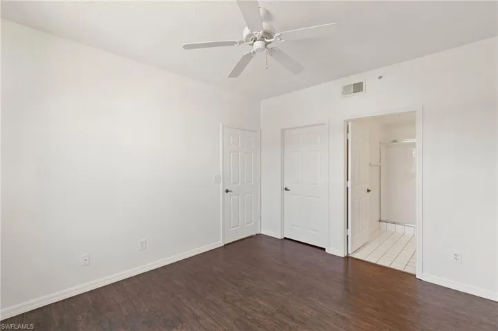 Unfurnished bedroom featuring dark wood-style flooring and ceiling fan