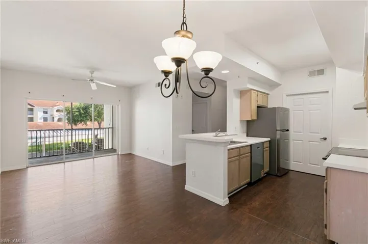 Kitchen featuring appliances with stainless steel finishes, a ceiling fan, open floor plan, light countertops, and dark wood-style flooring