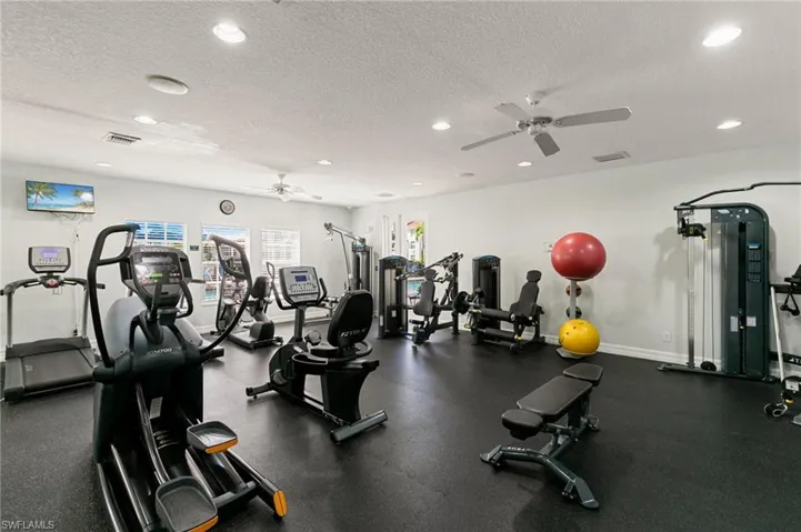 Gym featuring ceiling fan, recessed lighting, and a textured ceiling