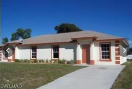 Ranch-style house featuring a front yard and concrete driveway