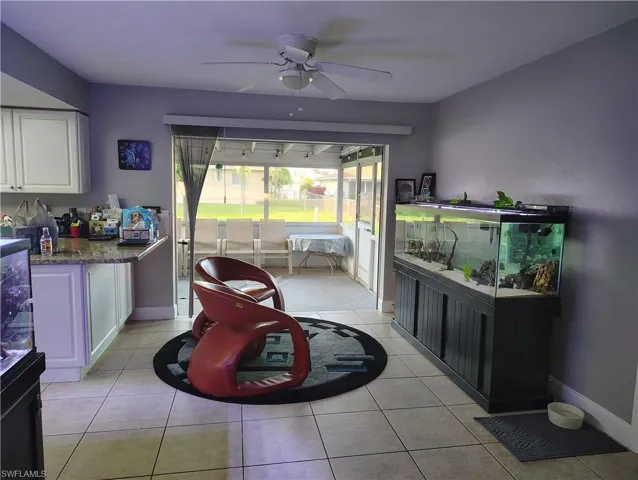 Dining space featuring ceiling fan, baseboards, and light tile patterned floors