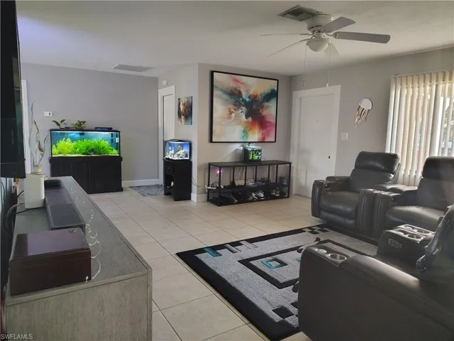 Living area with visible vents, ceiling fan, and light tile patterned floors