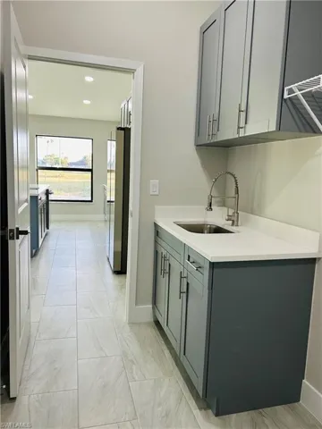 Laundry with sink, and gray cabinets