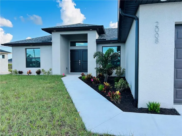 Entrance to property with a lawn