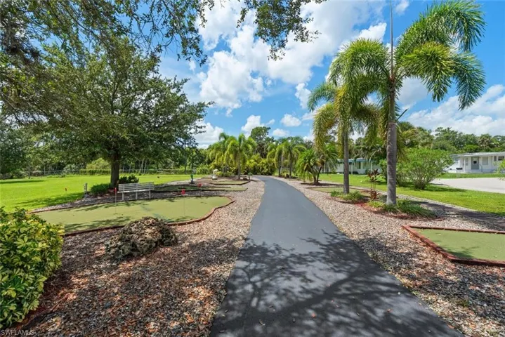 Surrounding community featuring a putting area and a lawn