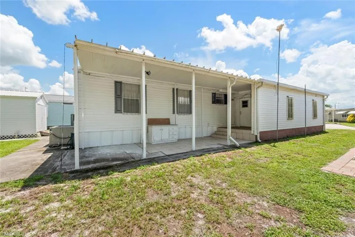 Back of property featuring a yard and entry steps