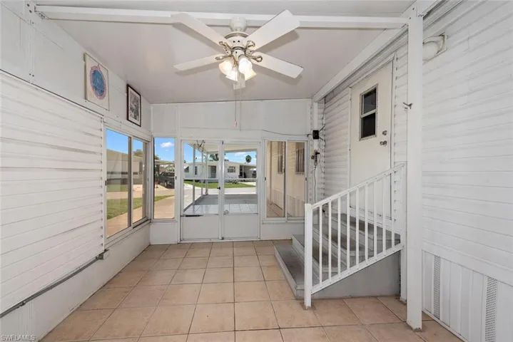 Unfurnished sunroom featuring ceiling fan