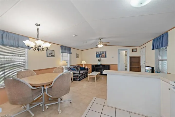 Dining area with a chandelier, vaulted ceiling, and a ceiling fan