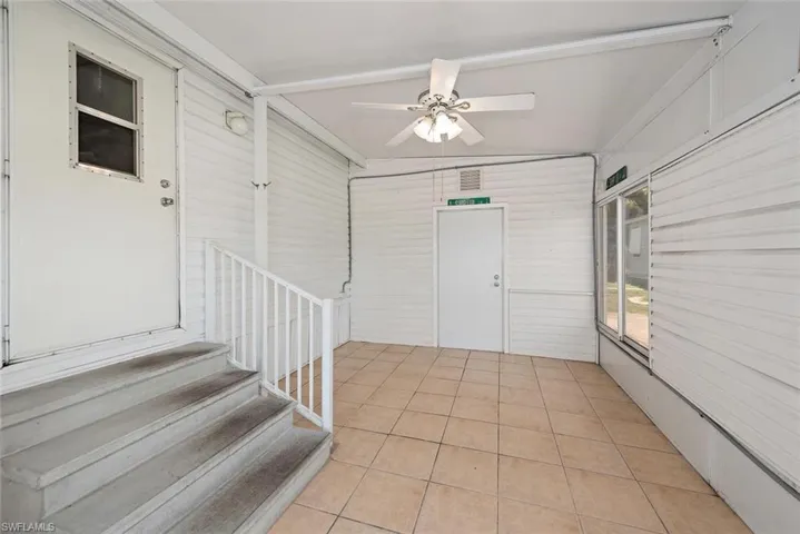 Unfurnished sunroom featuring a ceiling fan