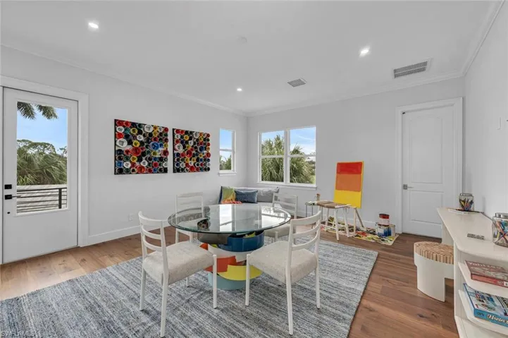 Dining space with ornamental molding and hardwood / wood-style floors