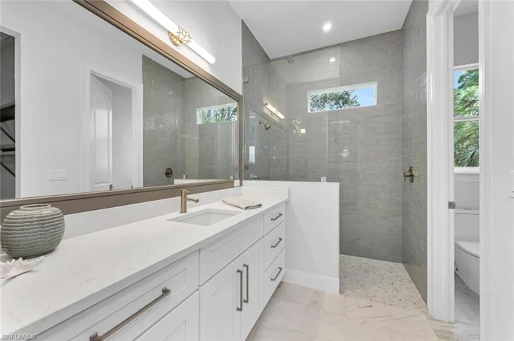 Bathroom with vanity, toilet, and a tile shower