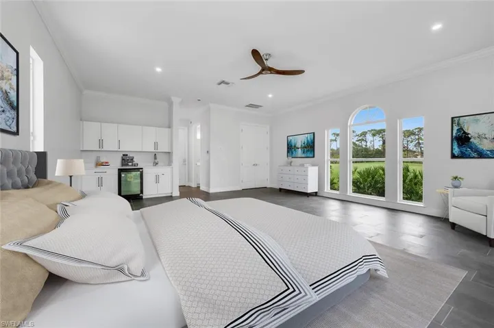 Bedroom with ceiling fan, crown molding, and beverage cooler