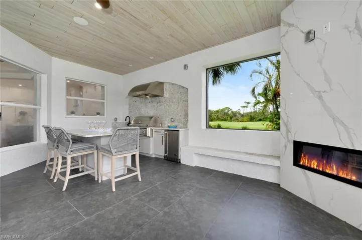Dining space featuring a high end fireplace, wood ceiling, and dark tile patterned flooring