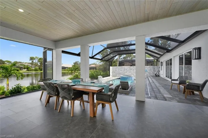 Sunroom / solarium featuring vaulted ceiling, a water view, and wooden ceiling