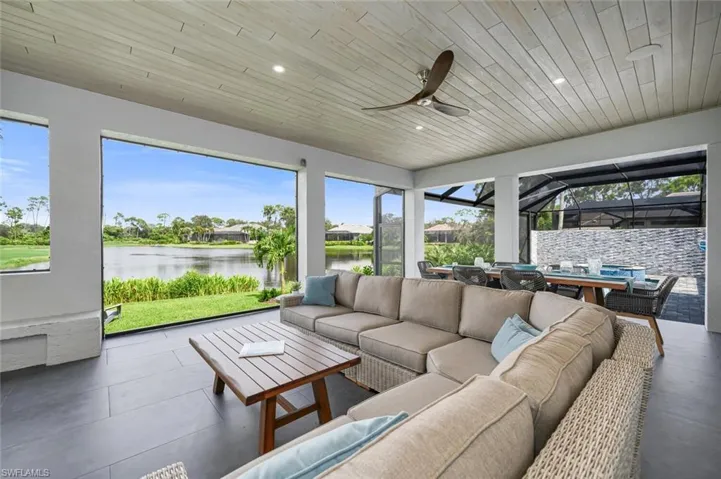 Sunroom / solarium featuring ceiling fan, wooden ceiling, a water view, and a wealth of natural light