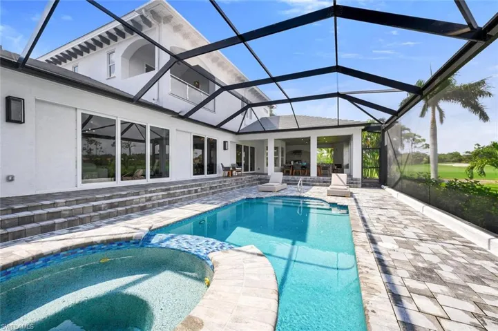 View of pool featuring an in ground hot tub, a patio, and glass enclosure