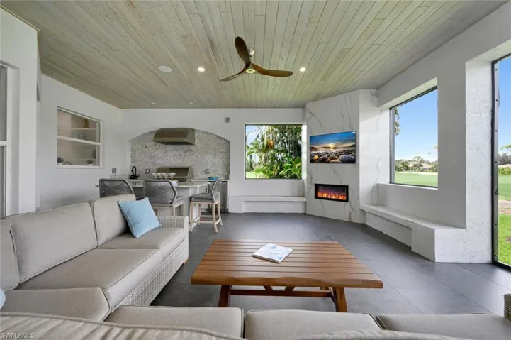Living room featuring wood ceiling, a fireplace, and ceiling fan