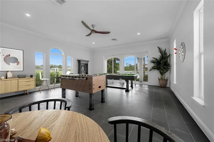 Rec room with crown molding, ceiling fan, billiards, and plenty of natural light