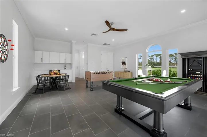 Game room featuring dark tile patterned flooring, ceiling fan, ornamental molding, and pool table