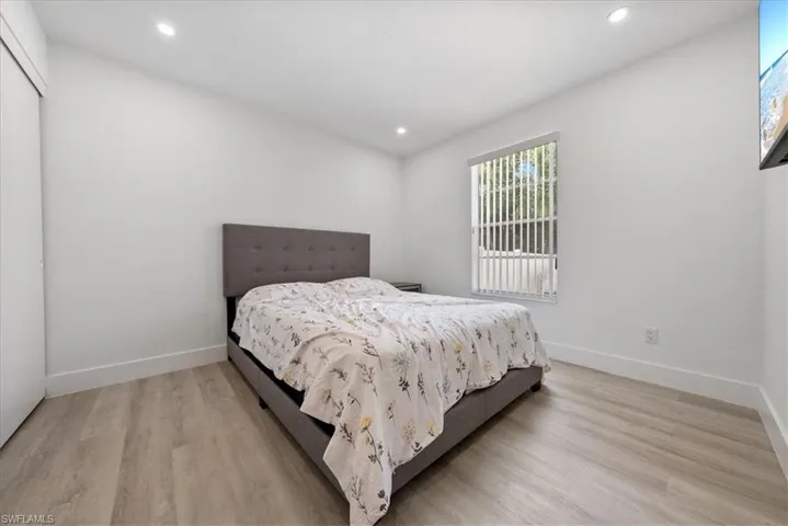 Bedroom with recessed lighting, light wood-style flooring, and a closet