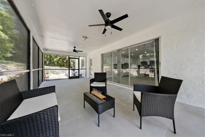 Sunroom featuring outdoor lounge area, a ceiling fan, and a patio area